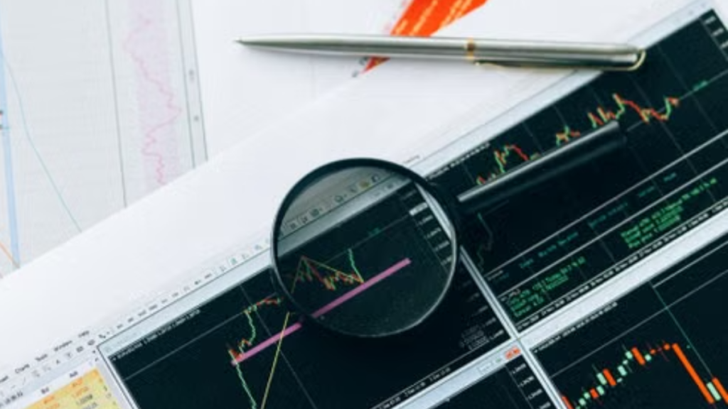 Magnifying glass and graphs depicting stock market data analysis on paper documents.